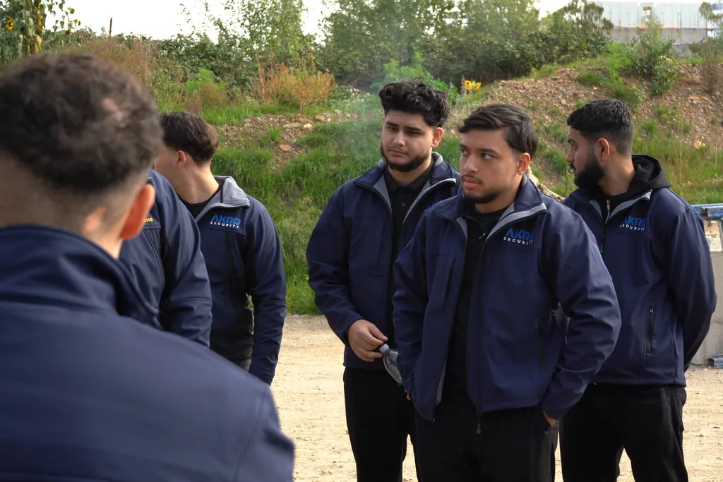 Einweisung vor dem Einsatz: Mitarbeitende von AKRO Security stehen in einer Gruppe im Freien zusammen